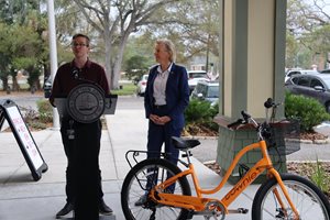 Parking Director Austin Britt and Tampa Mayor Jane Castor speak about the city's e-bike incentive, with a e-bike situated to the right